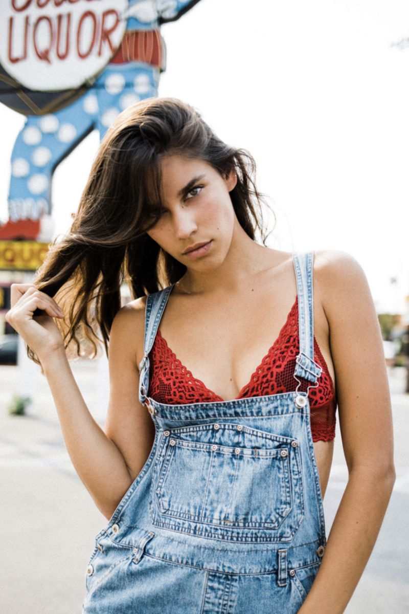 Balistarz-model-Samantha-Garza-casual-portrait-shoot-in-a-blue-denim-top-with-a-statue-holding-a-liquor-sign